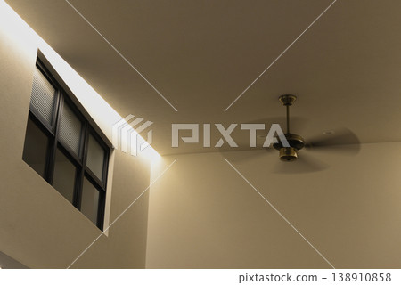 A modern, open-plan interior space with indirect lighting and a ceiling fan. A modern, open-plan interior space with indirect lighting and a ceiling fan. 138910858