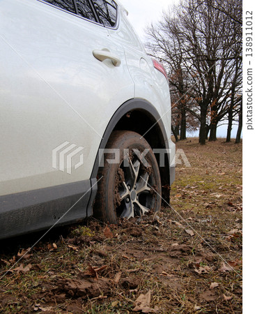 Rear car wheel fell into the mud in off road trip in forest Rear car wheel fell into the mud in off road trip in forest 138911012