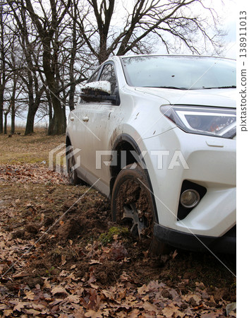 White utility vehicle in deep mud at the spring off road drive in forest White utility vehicle in deep mud at the spring off road drive in forest 138911013