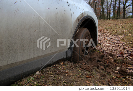 Wheel of white SUV in deep mud at the spring offroad 138911014
