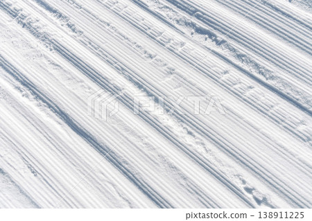 Bright winter ski trail. White striped ski run with tranquil morning shadows and calm ambiance Bright winter ski trail. White striped ski run with tranquil morning shadows and calm ambiance 138911225