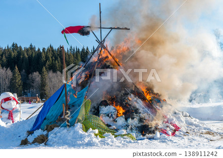 Burning down straw effigy at Maslenitsa festival with visible framework in intense fire Burning down straw effigy at Maslenitsa festival with visible framework in intense fire 138911242