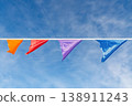Colorful triangular pennant flags hanging on a line against bright blue sky, close-up view 138911243