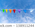 Colorful triangular pennant flags hanging on a line against bright blue sky 138911244