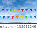 Colorful flags hang in sky above forest on sunny day during local celebration in countryside 138911246