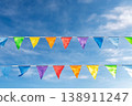 Colorful festive pennant flags hanging under bright wispy clouds sky 138911247