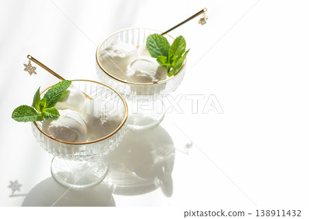 Vanilla Ice Cream in Elegant Glass Bowls on White Table with Sunlight Vanilla Ice Cream in Elegant Glass Bowls on White Table with Sunlight 138911432