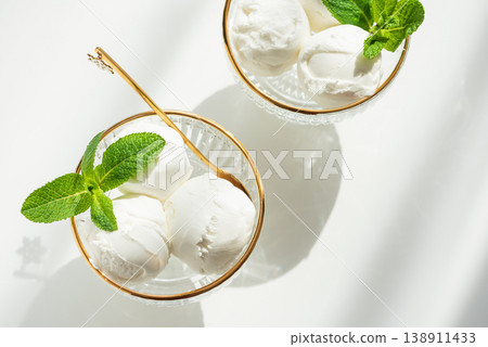 Vanilla Ice Cream in Elegant Glass Bowls on White Table with Sunlight 138911433