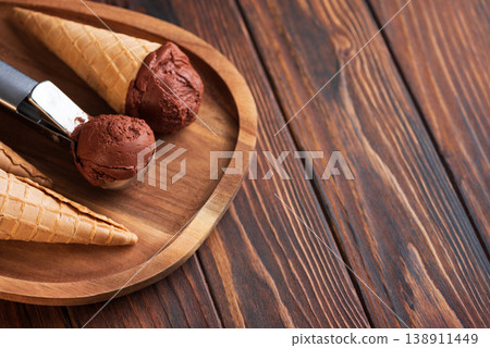 Chocolate Ice Cream with Waffle Cones on Dark Wooden Background Chocolate Ice Cream with Waffle Cones on Dark Wooden Background 138911449