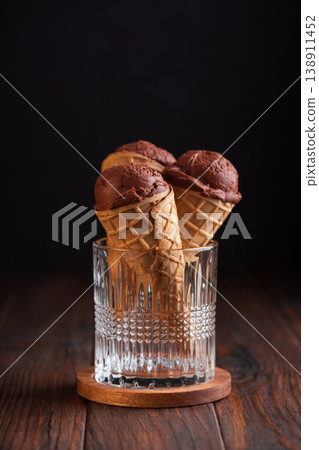 Chocolate Ice Cream Cones on Dark Wooden Background Chocolate Ice Cream Cones on Dark Wooden Background 138911452