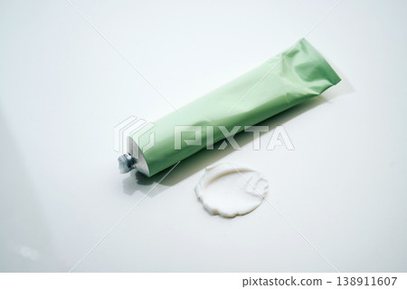 Cosmetic cream tube releasing skincare product swatch 138911607