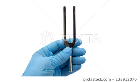 Hand holding a metal two-pronged tuning fork, isolated on transparent background, representing acoustic testing, audiology, and neurological examination 138912070