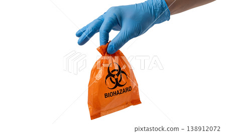 Gloved hand holding orange biohazard bag with the universal biohazard symbol, representing infectious waste disposal and laboratory safety protocols Gloved hand holding orange biohazard bag with the universal biohazard symbol, representing infectious waste disposal and laboratory safety protocols 138912072