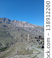 Kurta and Taga signal tower ruins, North Ossetia, Russia. Broken medieval watchtower walls with Caucasus Mountains in the background 138912200