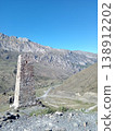 Kurta and Taga tower remains, North Ossetia, Russia. Historic signal tower ruins standing against a backdrop of Caucasus peaks under a bright sky 138912202