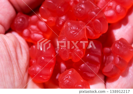 Food supplements. Vitamins jelly gummy bears fruits raspberry shape red candy in a female hand. Food supplements. Vitamins jelly gummy bears fruits raspberry shape red candy in a female hand. 138912217