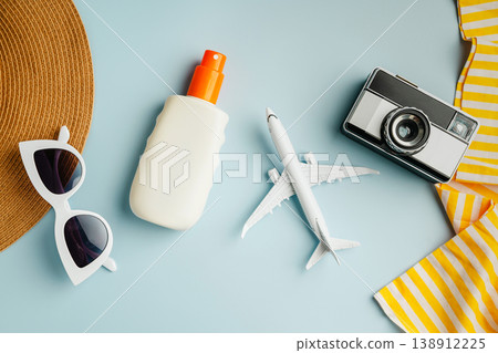 Summer flat lay, sunglasses, beach accessories, photo camera and model plane on blue background. Summer holiday background Summer flat lay, sunglasses, beach accessories, photo camera and model plane on blue background. Summer holiday background 138912225
