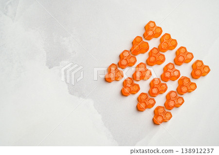 Orange vitamins jelly gummies on bright background, food supplements with copy space, top view Orange vitamins jelly gummies on bright background, food supplements with copy space, top view 138912237
