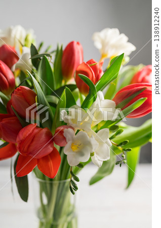 Spring floral background. Red tulips and Fresia white flower bouquet. Copy space 138912240