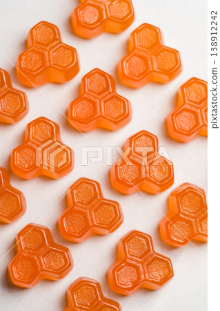 Orange vitamins jelly gummies on bright background, food supplements, top view Orange vitamins jelly gummies on bright background, food supplements, top view 138912242
