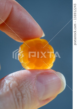 Food supplements. Vitamins jelly gummies fruit orange raspberry shaped in a female hands, close-up Food supplements. Vitamins jelly gummies fruit orange raspberry shaped in a female hands, close-up 138912243
