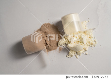 Vanilla and chocolate whey protein powder in scoops, food supplements, bright background Vanilla and chocolate whey protein powder in scoops, food supplements, bright background 138912244