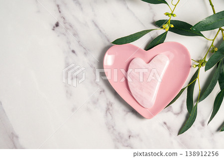 Rose quartz gua sha and eucalyptus leaves, abstract beauty photo. Copy space Rose quartz gua sha and eucalyptus leaves, abstract beauty photo. Copy space 138912256