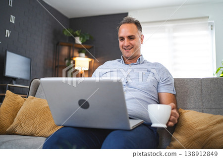 Middle aged Caucasian man using laptop on the sofa 138912849