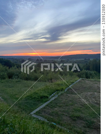Scenic sunset over hills in rural area with clouds and open fields at evening time Scenic sunset over hills in rural area with clouds and open fields at evening time 138912880