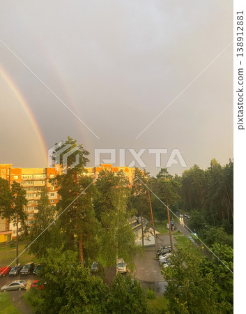 Double rainbow over residential buildings and forest after rain, cityscape with impressive sky and sunlight 138912881