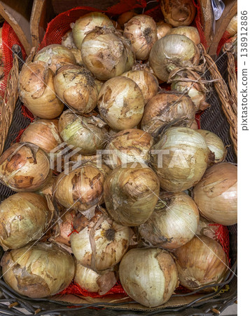 Fresh onions in a basket at a local market for sale during the daytime in autumn season 138912886