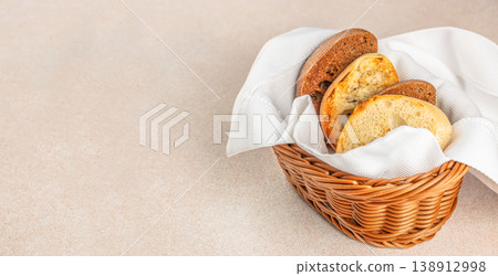 Assorted sliced bread in wicker basket with white napkin on light background and copy space for bakery advertising 138912998