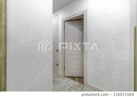 Slightly Ajar Classic White Door in Bright Hallway Interior 138913169