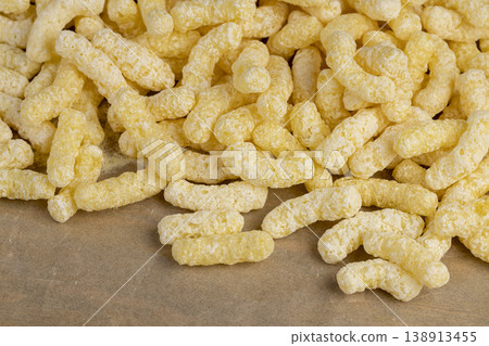 yellow large sweet sticks of corn flour with added sugar for quick cooking with milk or yogurt, corn sticks scattered on food paper yellow large sweet sticks of corn flour with added sugar for quick cooking with milk or yogurt, corn sticks scattered on food paper 138913455