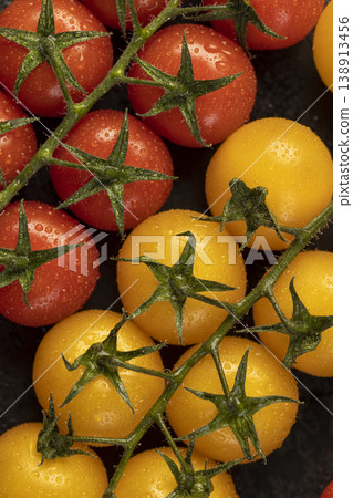 wet round fresh and sweet tomatoes of yellow color lie on the table, yellow tomatoes with dots on the peel, a large number of freshly picked tomatoes covered with drops of water wet round fresh and sweet tomatoes of yellow color lie on the table, yellow tomatoes with dots on the peel, a large number of freshly picked tomatoes covered with drops of water 138913456