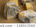 an old spoiled orange cheese with a lot of colorful mold, an inedible and dangerous cheese , the cheese is covered with mold dangerous to health 138913560