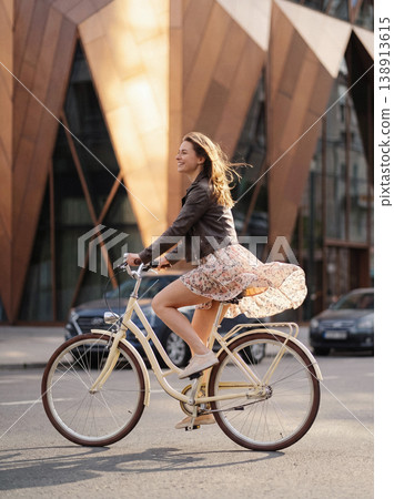 Woman enjoying city cycling feeling freedom and movement 138913615