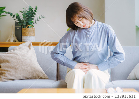 Middle-aged woman suffering from stomach pain Middle-aged woman suffering from stomach pain 138913631
