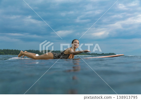 Determined Young Woman Confidently Paddling At Peaceful Seaside 138913795