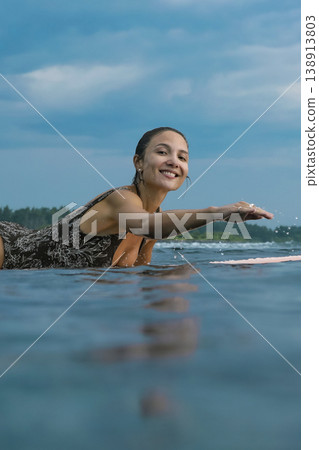 Energetic Woman With Bright Smile Engaged In Coastal Surfing Adventure 138913803