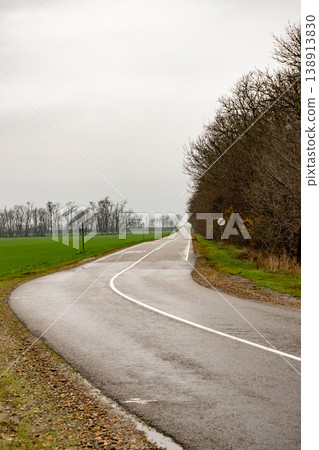 winding road through fields during a cloudy day. traveling. winding road through fields during a cloudy day. traveling. 138913830