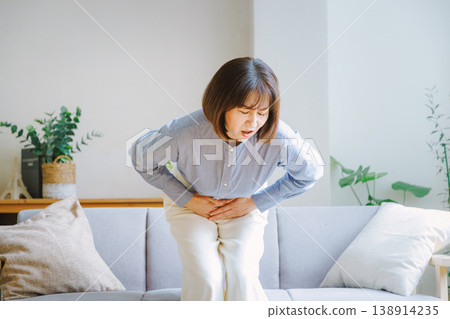 Middle-aged woman suffering from stomach pain Middle-aged woman suffering from stomach pain 138914235