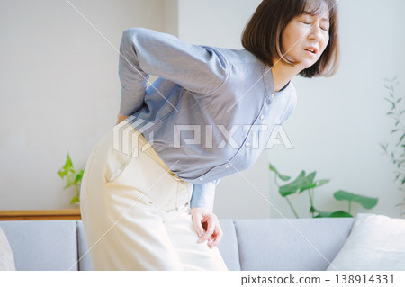 Middle-aged woman suffering from back pain Middle-aged woman suffering from back pain 138914331