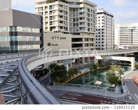 The curve of the Okinawa Yui Rail elevated track and the cityscape of Naha | Transportation infrastructure advertising, business materials, and tourism promotion 138915110