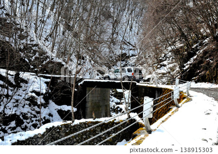 An SUV driving along the Daibosatsu Pass forest road in early spring, where snow still remains. An SUV driving along the Daibosatsu Pass forest road in early spring, where snow still remains. 138915303