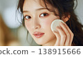 A close-up of a beautiful woman applying foundation to her cheeks in the fresh morning air. 138915666