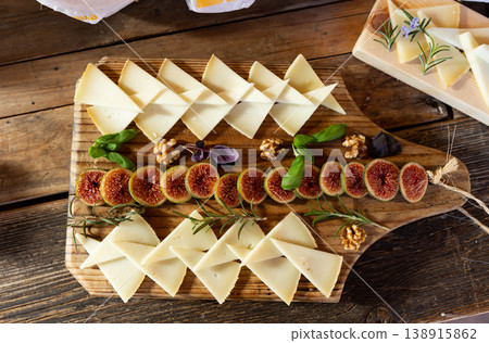 Cheese plate - cheeses and figs on wooden background Cheese plate - cheeses and figs on wooden background 138915862