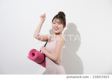 A woman with a yoga mat against a white background, healthy and beautiful, training in sports, gym, lifestyle and diet. A woman with a yoga mat against a white background, healthy and beautiful, training in sports, gym, lifestyle and diet. 138915925
