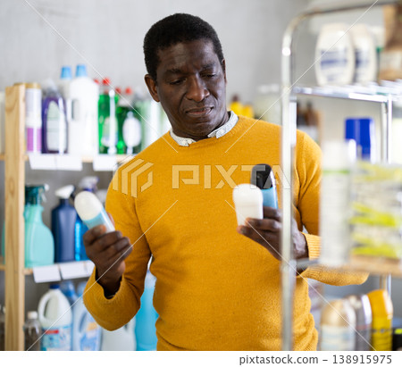 Man chooses deodorant aerosol can or air freshener in supermarket 138915975