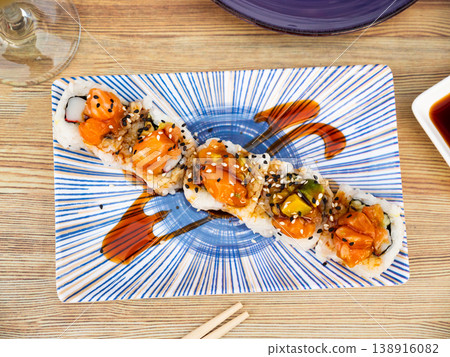 Saketaki roll served with soya sauce and wasabi in a plate Saketaki roll served with soya sauce and wasabi in a plate 138916082